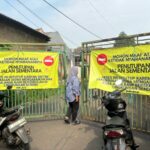 Gerbang menuju SMPN 17 dan SMAN 6 Tangsel masih ditutup oleh warga, Senin (14/7). Foto: Andre Pradana/Tangselife