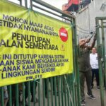 Petugas gabungan saat membongkar akses penutup menuju SMPN 17 dan SMAN 6 Tangsel, Senin (14/7). Foto: Andre Pradana/Tangselife